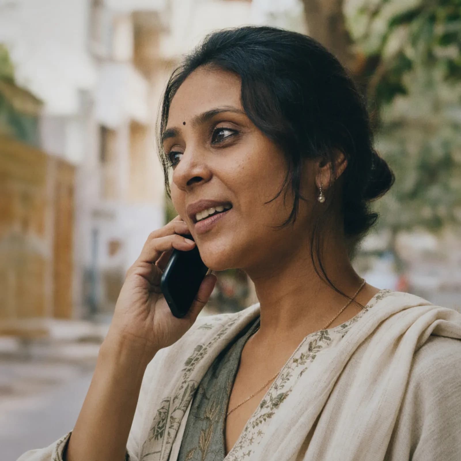 A woman on a phone call outdoors, looking relieved